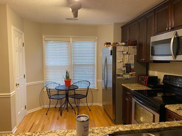 109 Tabula Place Cary, NC 27513 - Photo 11 of 26 a kitchen with stainless steel appliances kitchen island granite countertop a stove top oven a sink a dining table and chairs