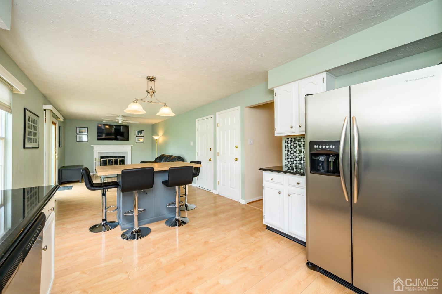 709 Henderson Road Lumberton, NJ 08048 - Photo 13 of 46 a kitchen with stainless steel appliances kitchen island granite countertop a refrigerator a stove a dining table and chairs with wooden floor
