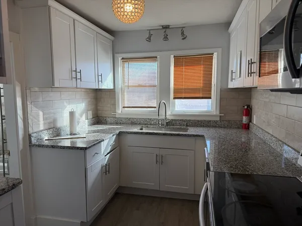 a kitchen with stainless steel appliances granite countertop a sink stove and cabinets