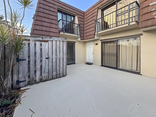 a view of a house with a wooden fence