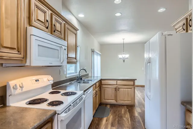 a kitchen that has a sink a stove and a refrigerator
