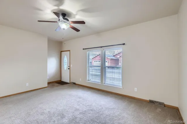 a view of an empty room with a ceiling fan