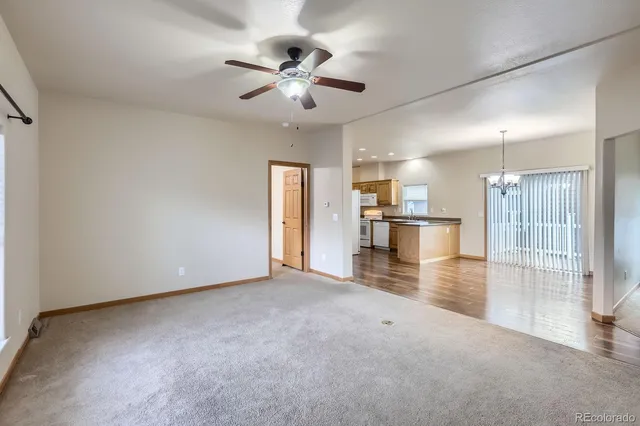 a view of a livingroom with a ceiling fan wooden floor and a ceiling fan