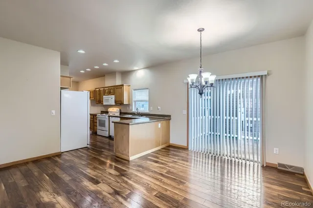 a view of kitchen with granite countertop cabinets and refrigerator
