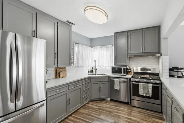 a kitchen with stainless steel appliances a refrigerator sink and cabinets