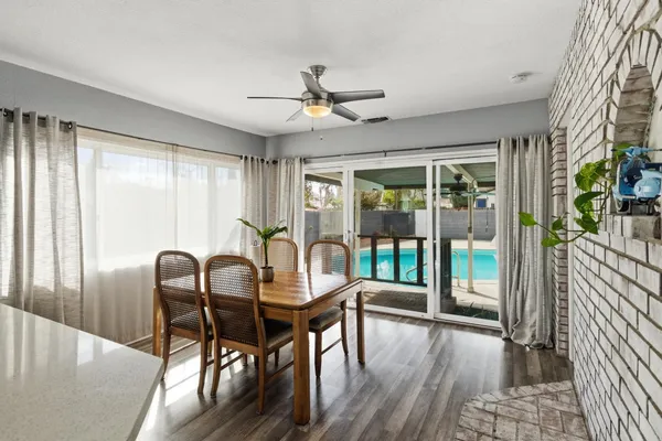 a dining room with furniture a chandelier and wooden floor