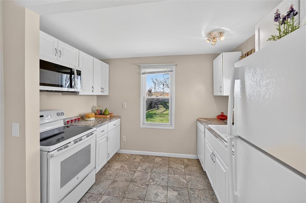 314 Fort Couch Road Pittsburgh, PA 15241 - Photo 7 of 26 a kitchen with cabinets a window and a refrigerator