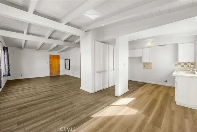 a view of a room with wooden floor and white walls