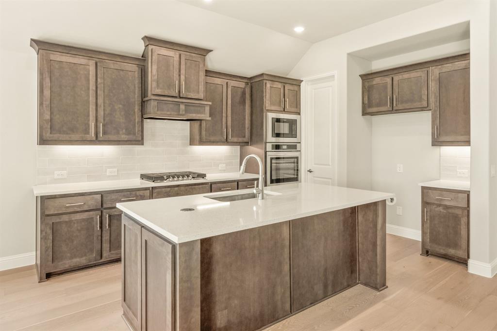 1098 Foxtail Drive Justin, TX 76247 - Photo 17 of 40 a kitchen with stainless steel appliances granite countertop a sink stove and refrigerator