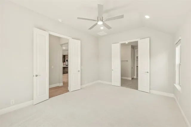 an empty room with closet and a ceiling fan