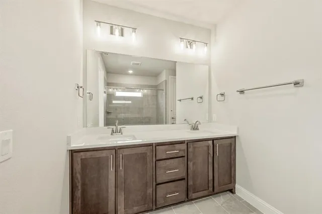 a bathroom with a double vanity sink and a mirror