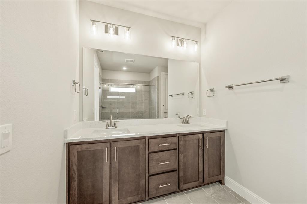 1098 Foxtail Drive Justin, TX 76247 - Photo 24 of 40 a bathroom with a double vanity sink and a mirror