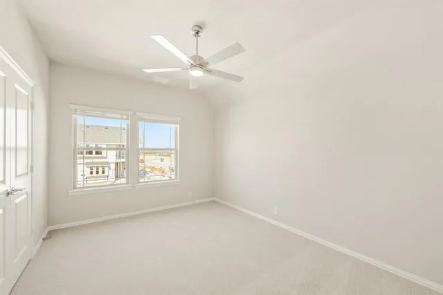 an empty room with a window and a fan