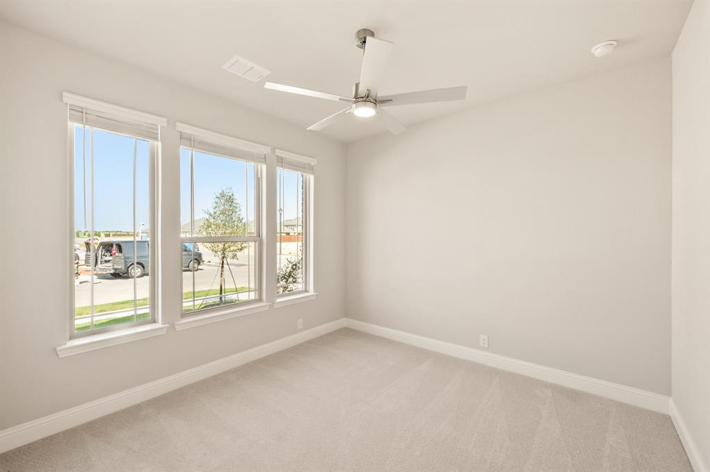 1098 Foxtail Drive Justin, TX 76247 - Photo 6 of 40 en empty room with windows and ceiling fan