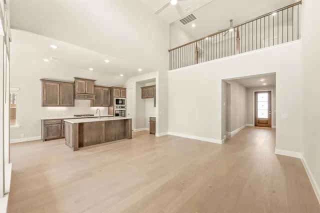 a large white kitchen with kitchen island a sink stainless steel appliances and cabinets