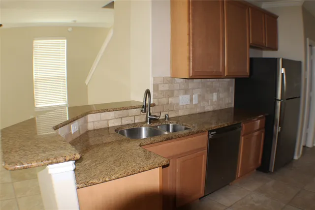 an empty room with wooden floor closet and windows