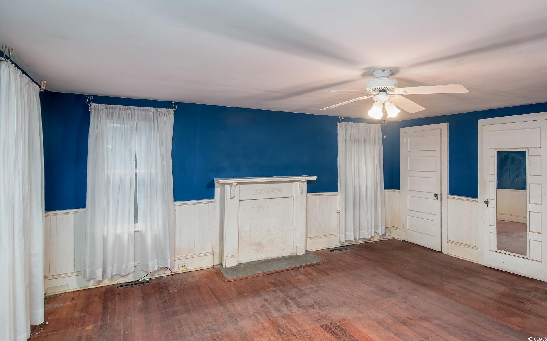 1010 Highmarket Street Georgetown, SC 29440 - Photo 12 of 32 Unfurnished bedroom featuring hardwood / wood-style flooring, ceiling fan, and a wainscoted wall