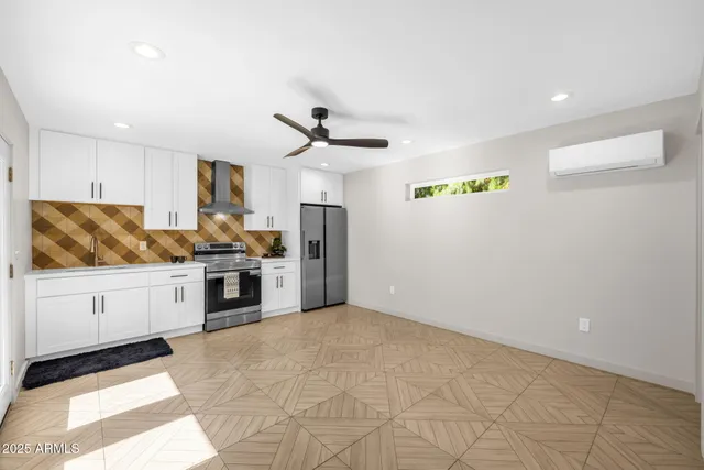 a kitchen with stainless steel appliances a refrigerator and white cabinets