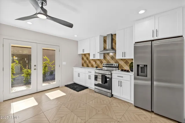 a kitchen with stainless steel appliances granite countertop a refrigerator a stove and a sink