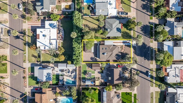 an aerial view of multi story residential apartment building with yard and parking