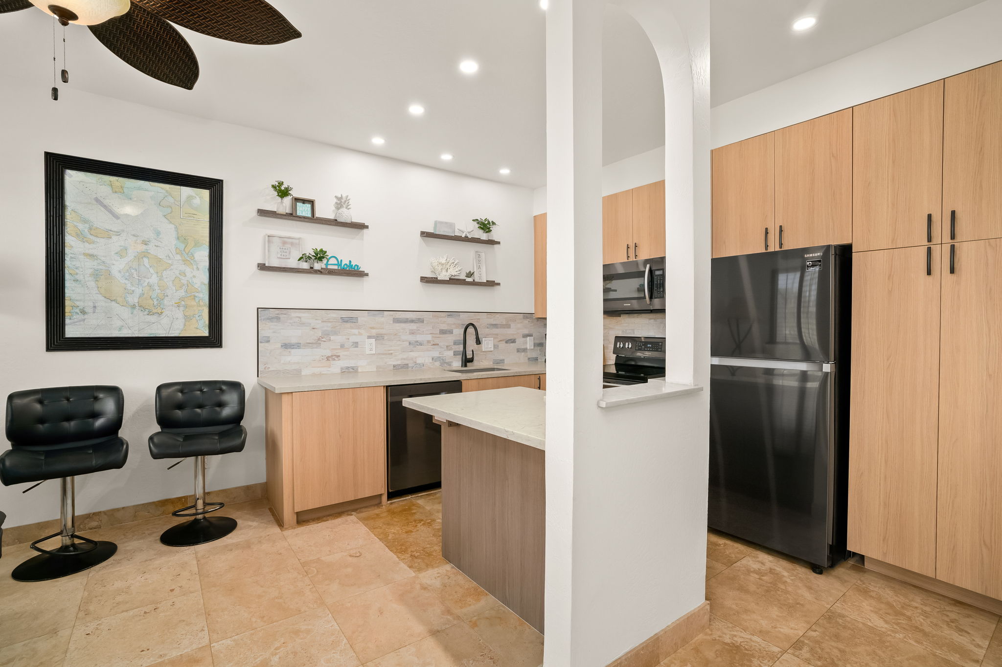1901 Poipu Road, Unit 212 Koloa, HI 96756 - Photo 2 of 8 a kitchen with stainless steel appliances kitchen island granite countertop a refrigerator and a stove
