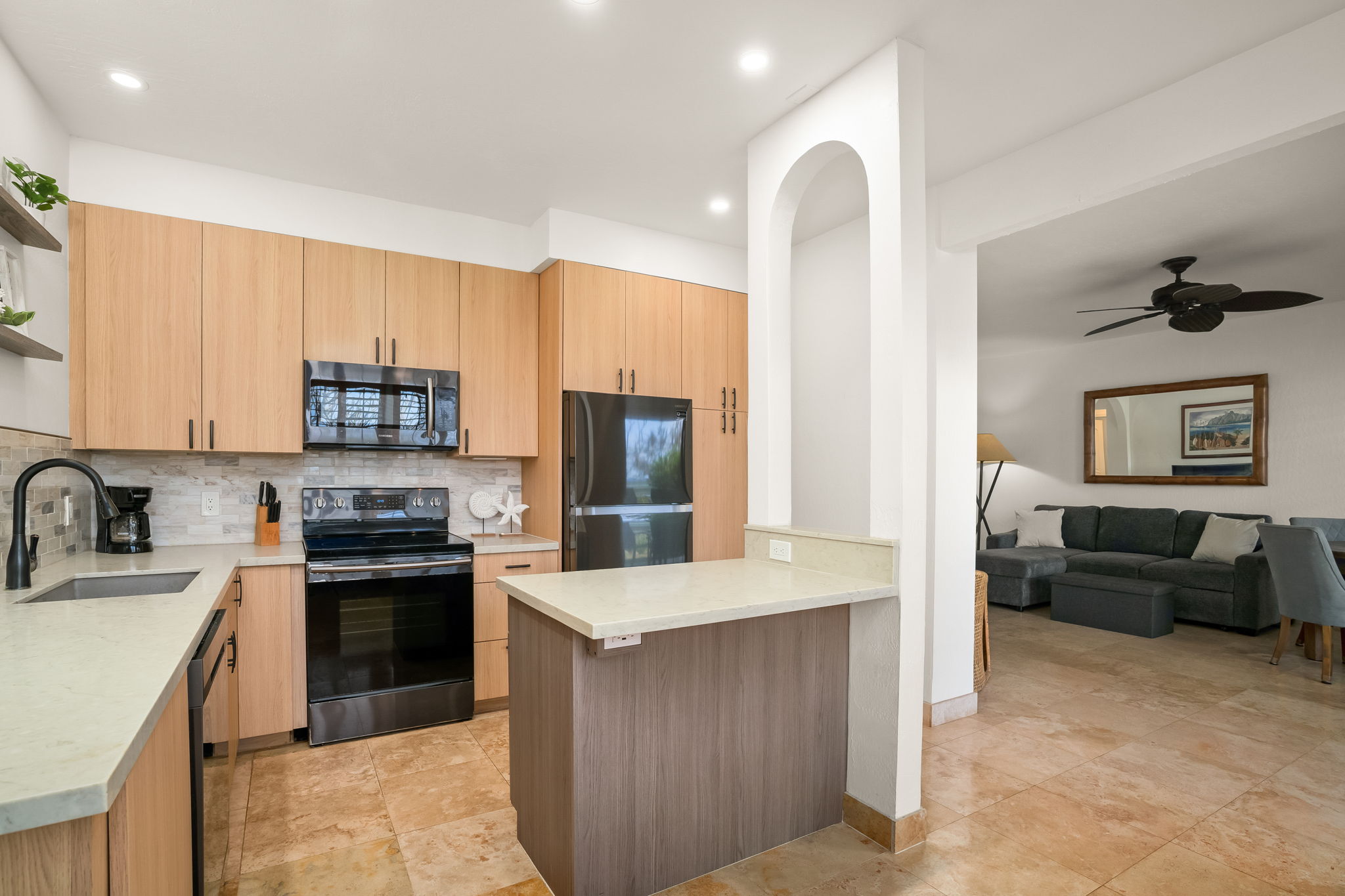 1901 Poipu Road, Unit 212 Koloa, HI 96756 - Photo 6 of 30 a kitchen with stainless steel appliances granite countertop a stove top oven a sink a refrigerator and white cabinets with wooden floor
