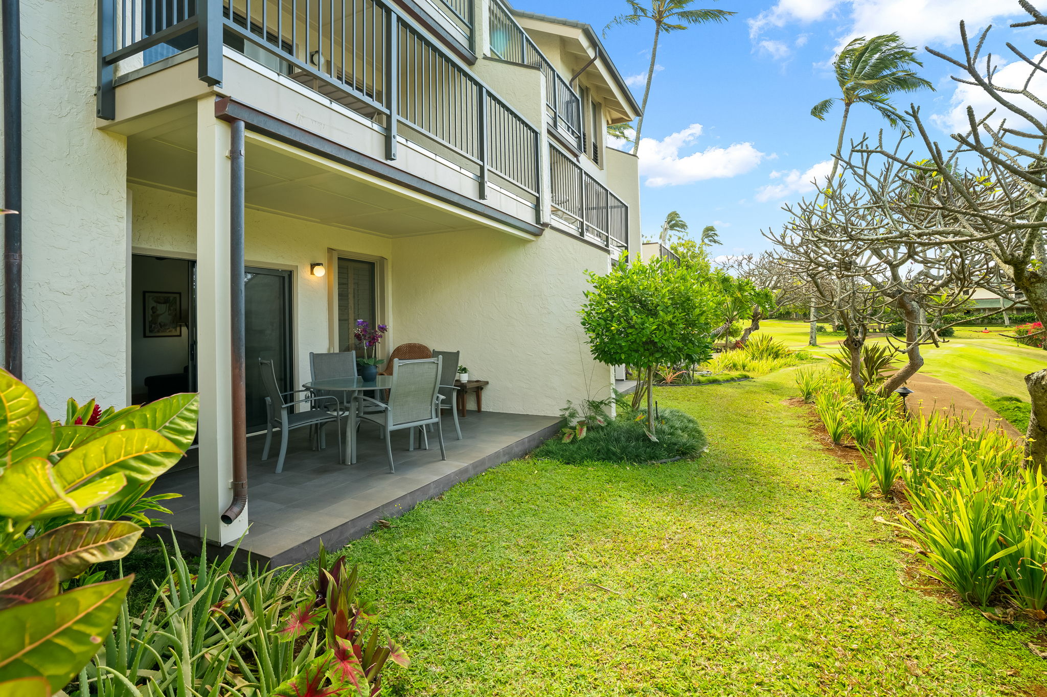 1901 Poipu Road, Unit 212 Koloa, HI 96756 - Photo 7 of 8 a view of a patio with table and chairs and potted plants