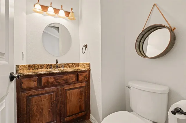 a bathroom with a toilet a sink and a mirror