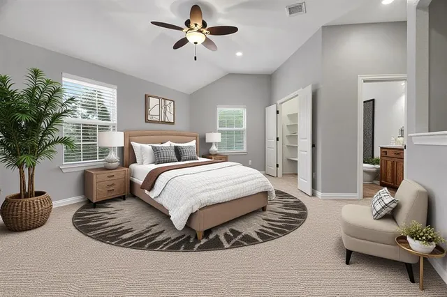 a spacious bedroom with a bed a chandelier and a couch