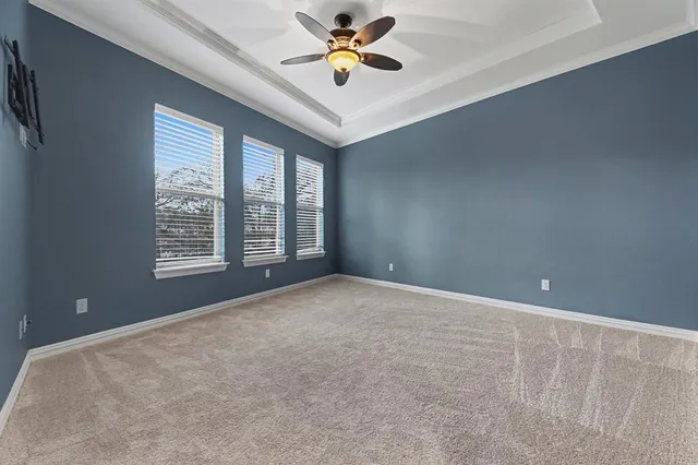 a view of an empty room with a window and a ceiling fan