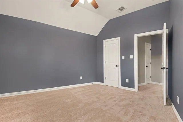 an empty room with closet and a chandelier fan