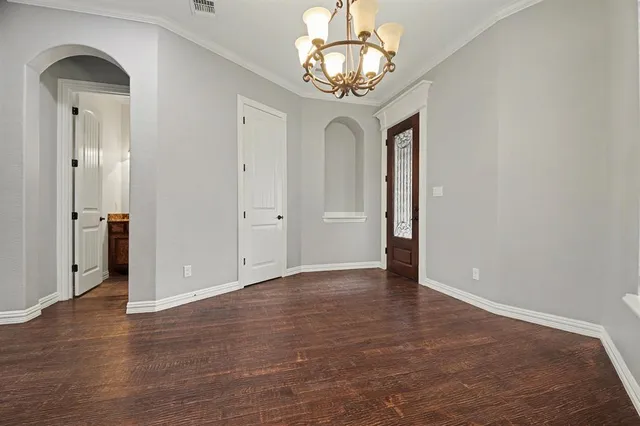 a view of a hallway with wooden floor and chandelier