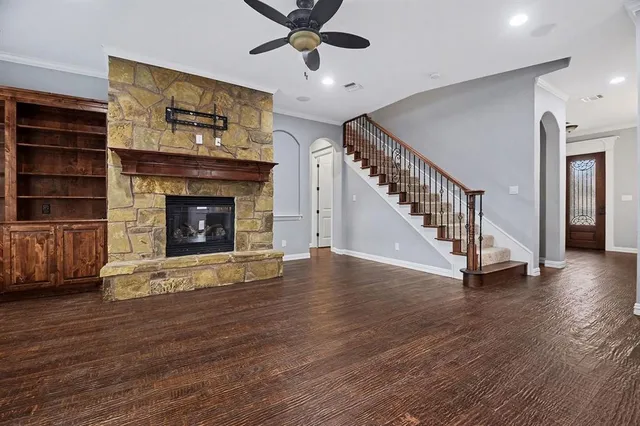 a view of an empty room with wooden floor fireplace and a window