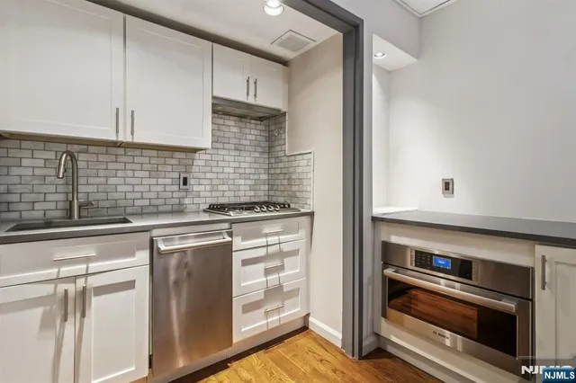 a kitchen with white cabinets and appliances