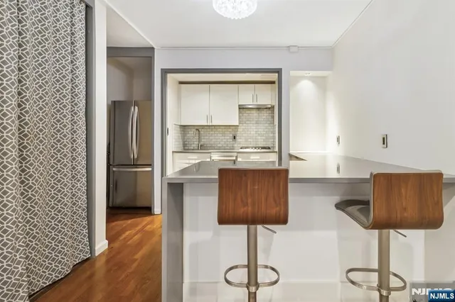 a kitchen with stainless steel appliances kitchen island sink refrigerator and stove