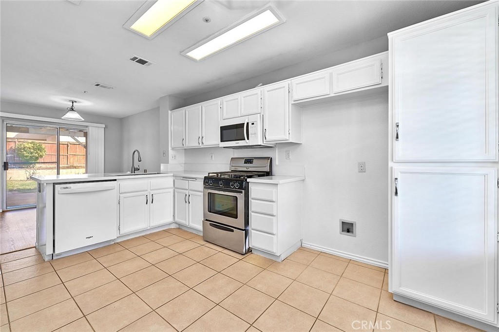 5280 Melbourne Place Riverside, CA 92508 - Photo 23 of 59 a kitchen with white cabinets and appliances