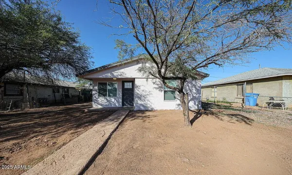 a view of a backyard with table and chairs under a large tree