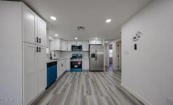 a large kitchen with a lot of counter space and stainless steel appliances