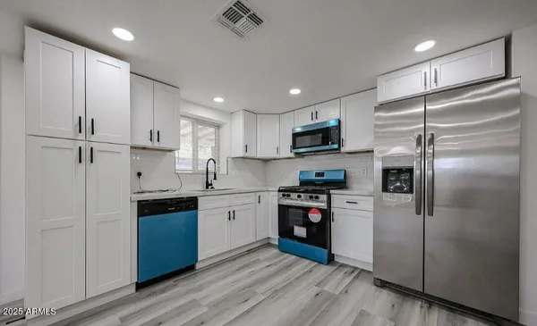 a kitchen with stainless steel appliances cabinets a sink and a stove