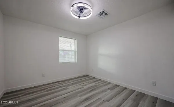 a view of a room with wooden floor and window