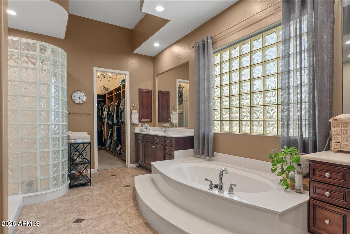 6427 South Magic Court Gilbert, AZ 85298 - Photo 13 of 71 a white bath tub sitting in a en suite bathroom next to a window