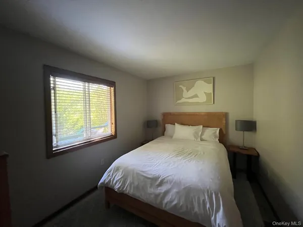 a bed sitting in a bedroom next to a window