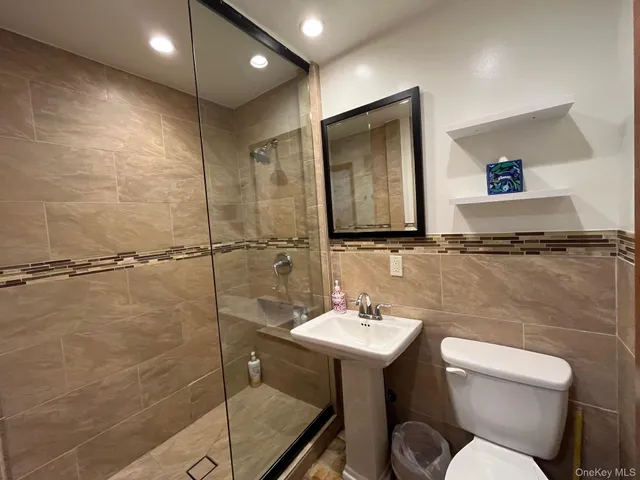 a bathroom with a sink mirror toilet and shower