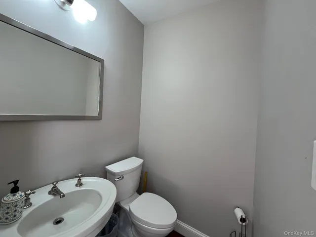 a bathroom with a sink a toilet and mirror