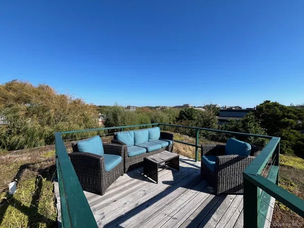 a view of a roof deck with couches and sky view
