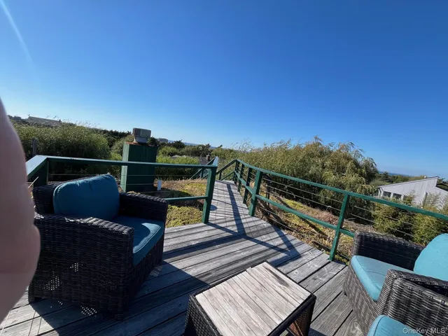a view of a roof deck with wooden floor and city view