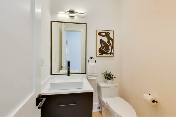 a bathroom with a granite countertop sink a toilet a mirror and shower
