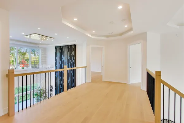 an empty room with windows and chandelier fan