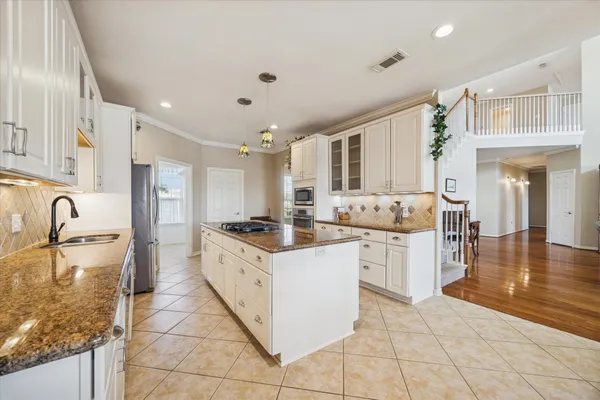 a large kitchen with stainless steel appliances granite countertop a sink and cabinets
