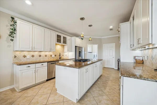 a kitchen with granite countertop a sink stove top oven and cabinets